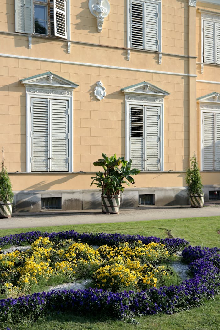 Home Charming garden with vibrant flowers beside an elegant European building exterior.